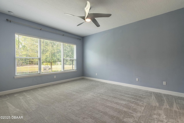 spare room featuring ceiling fan, light carpet, and a textured ceiling