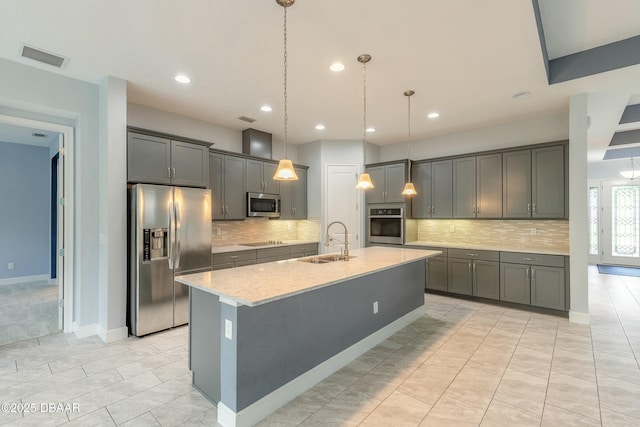 kitchen featuring gray cabinets, appliances with stainless steel finishes, sink, and a kitchen island with sink