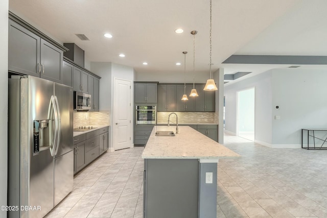 kitchen with pendant lighting, sink, a kitchen island with sink, gray cabinetry, and stainless steel appliances