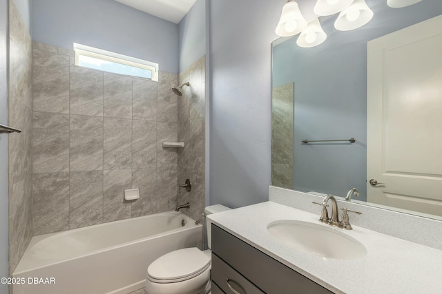 full bathroom featuring tiled shower / bath, vanity, and toilet