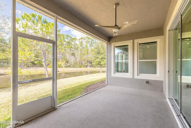 unfurnished sunroom with ceiling fan