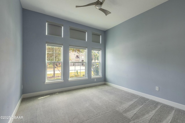 carpeted spare room featuring ceiling fan