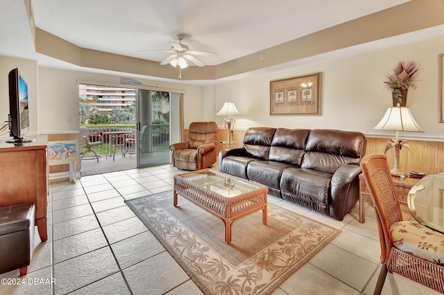 tiled living room featuring wooden walls and ceiling fan