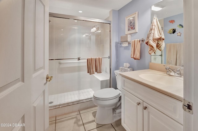 bathroom featuring toilet, vanity, tile patterned flooring, and a shower with door