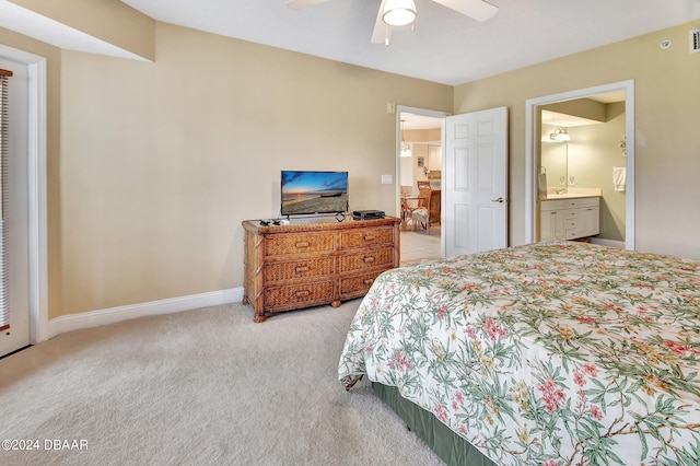 bedroom featuring connected bathroom, light carpet, and ceiling fan