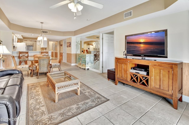 living room with light tile patterned floors and ceiling fan with notable chandelier