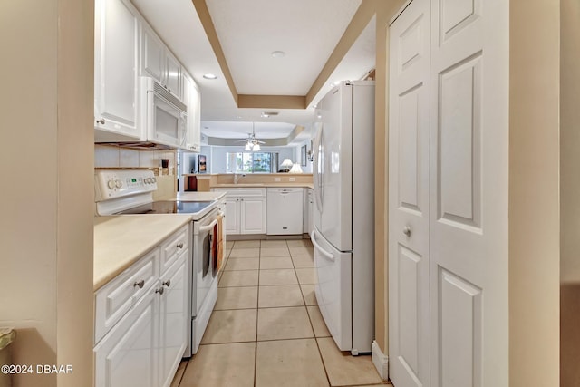 kitchen featuring white appliances, light tile patterned floors, decorative backsplash, white cabinets, and kitchen peninsula