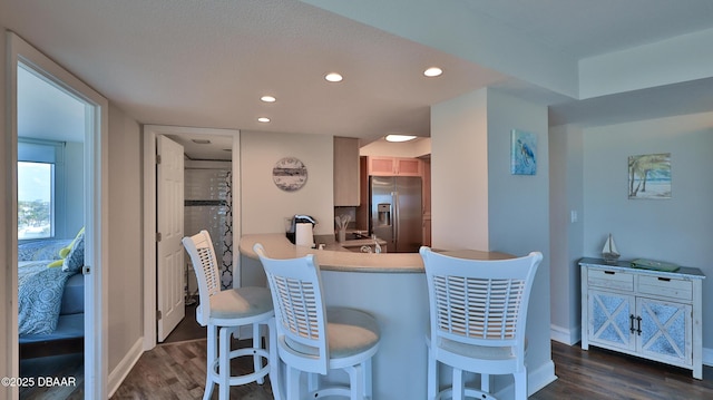 2625 S Atlantic Ave Unit 5Sw, Daytona Beach, FL 32118 - kitchen featuring stainless steel fridge with ice dispenser, dark wood finished floors, a kitchen breakfast bar, recessed lighting, and light countertops