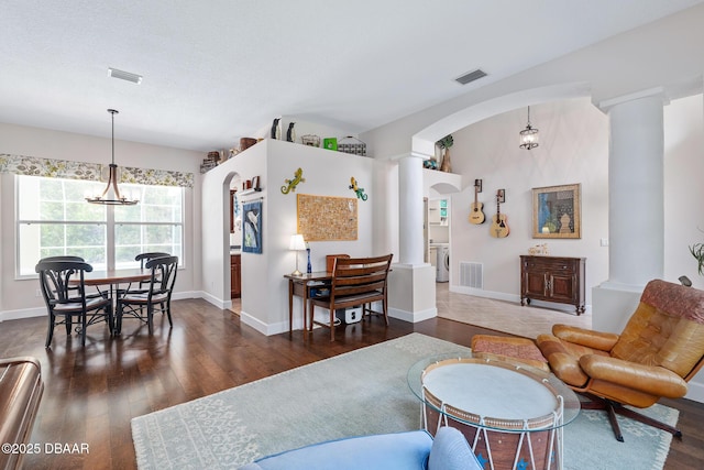 1214 Hampstead Ln, Ormond Beach, FL 32174 - living room featuring decorative columns, dark wood-style flooring, a chandelier, and arched walkways