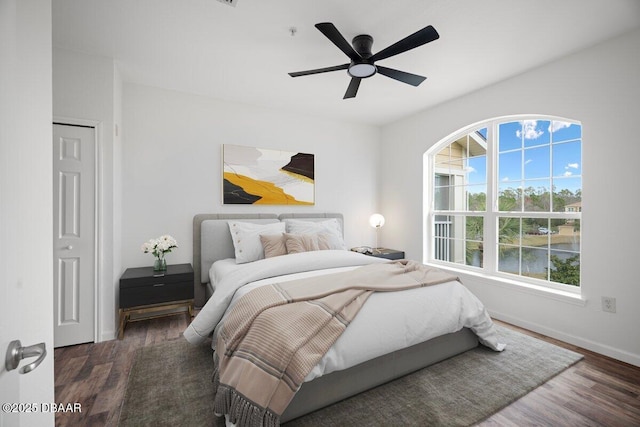 bedroom with dark hardwood / wood-style floors and ceiling fan