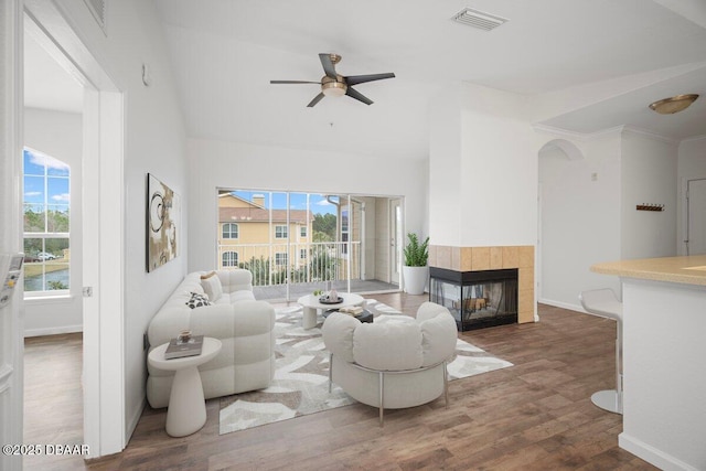 living room featuring ceiling fan, a fireplace, and dark hardwood / wood-style flooring