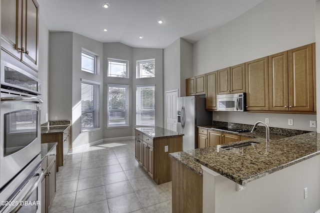 408 Chelsea Place Ave, Ormond Beach, FL 32174 - kitchen with appliances with stainless steel finishes, a sink, baseboards, dark stone countertops, and a high ceiling