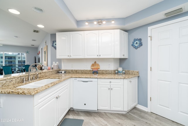 kitchen featuring dishwasher, kitchen peninsula, white cabinets, and sink