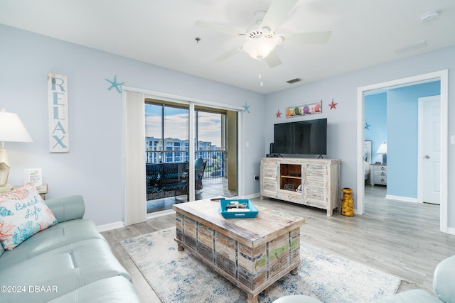 living room featuring light hardwood / wood-style flooring and ceiling fan