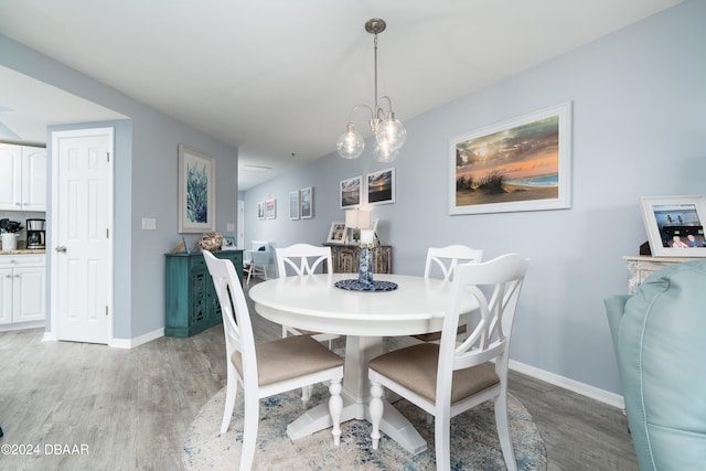 dining space featuring light hardwood / wood-style flooring and a notable chandelier