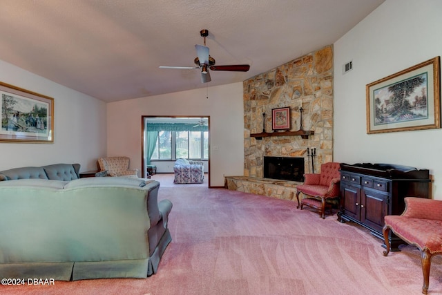 carpeted living room with lofted ceiling, a textured ceiling, ceiling fan, and a stone fireplace