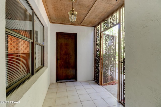 doorway to outside with wood ceiling and light tile patterned flooring