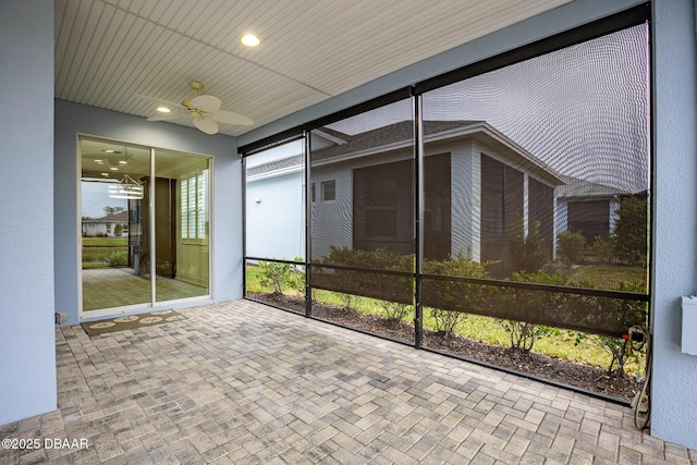 unfurnished sunroom with ceiling fan