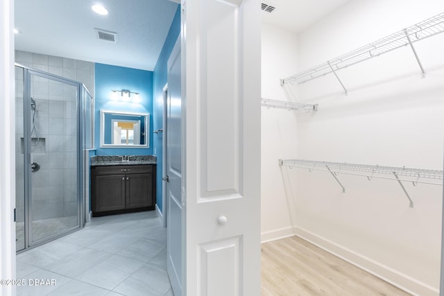 bathroom featuring a shower with door, vanity, and hardwood / wood-style floors