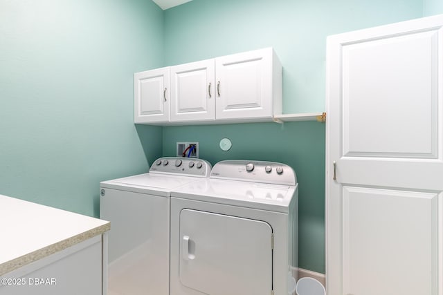 laundry area with cabinets and washing machine and clothes dryer