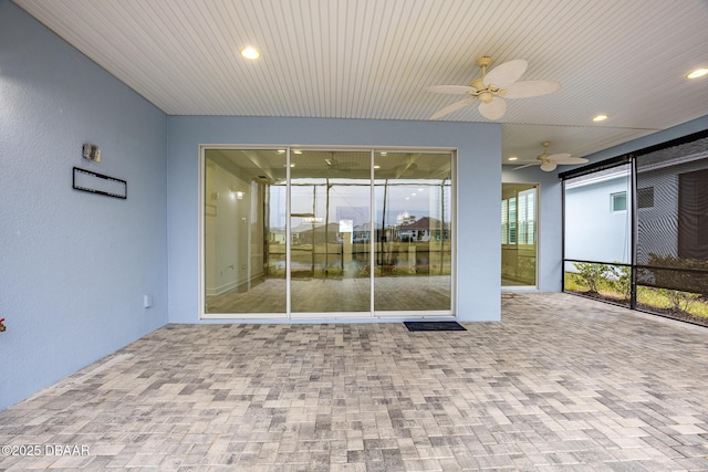 unfurnished sunroom with ceiling fan