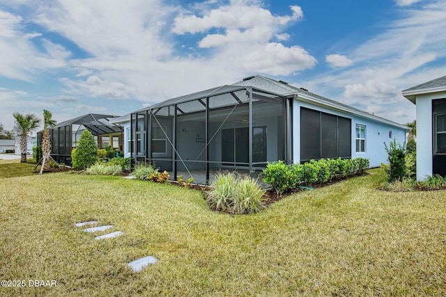 rear view of property with a yard and glass enclosure