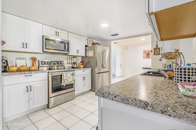 3618 Dame St, Port Orange, FL 32129 - kitchen featuring stainless steel appliances, white cabinets, light tile patterned floors, recessed lighting, and light countertops