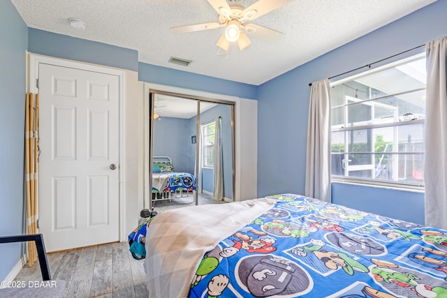3618 Dame St, Port Orange, FL 32129 - bedroom with wood finished floors, a closet, a textured ceiling, and a ceiling fan