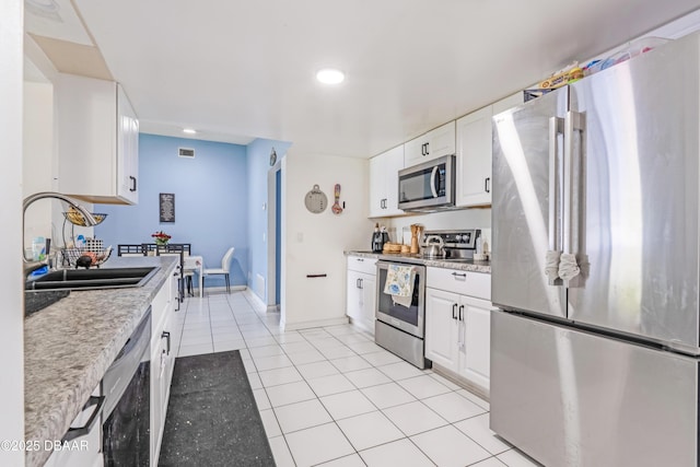 3618 Dame St, Port Orange, FL 32129 - kitchen with stainless steel appliances, light tile patterned floors, white cabinetry, and recessed lighting