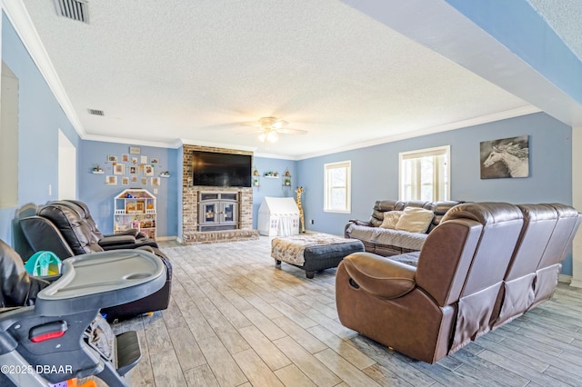 3618 Dame St, Port Orange, FL 32129 - living area with a textured ceiling, crown molding, light wood-type flooring, ceiling fan, and a fireplace