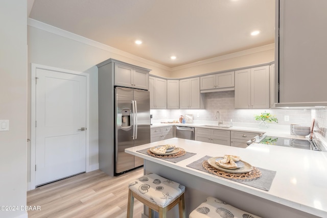 3066 Isles Way, New Smyrna Beach, FL 32168 - kitchen with stainless steel appliances, gray cabinetry, ornamental molding, decorative backsplash, and light countertops