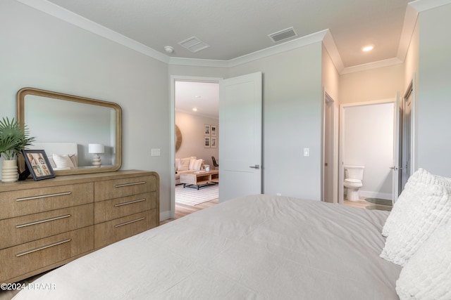 bedroom featuring light hardwood / wood-style floors, ensuite bath, and crown molding