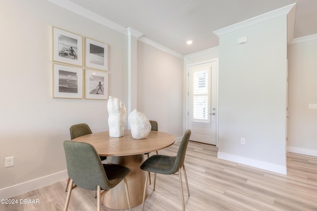 dining room with light hardwood / wood-style flooring and ornamental molding