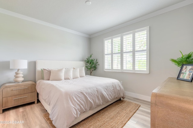 bedroom featuring light wood-type flooring and crown molding