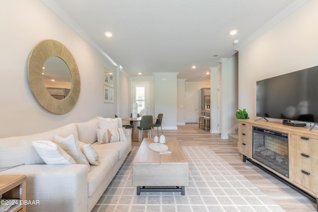 living room featuring crown molding and light hardwood / wood-style floors