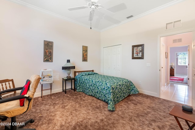 carpeted bedroom featuring ceiling fan, crown molding, and a closet