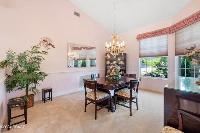 carpeted dining room with high vaulted ceiling and a chandelier