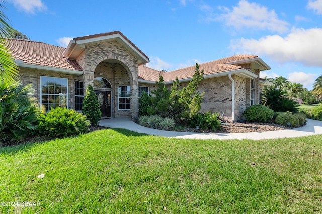 mediterranean / spanish home featuring a front yard