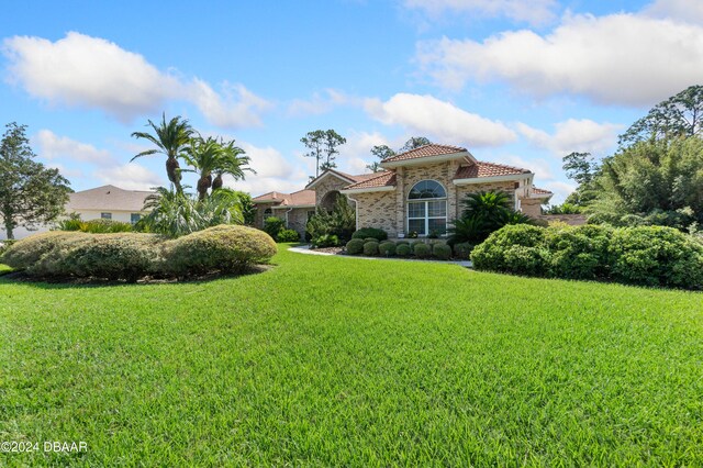 mediterranean / spanish-style home with a front lawn