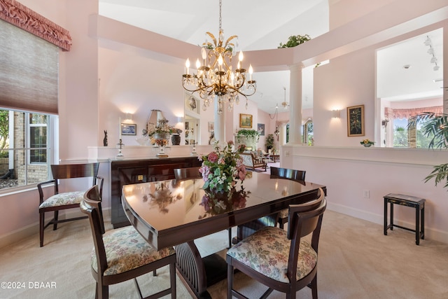 carpeted dining space featuring high vaulted ceiling, a notable chandelier, and ornate columns