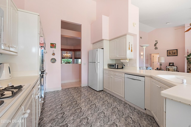 kitchen featuring white cabinetry, kitchen peninsula, ceiling fan with notable chandelier, high vaulted ceiling, and white appliances