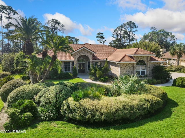 mediterranean / spanish house featuring a front lawn