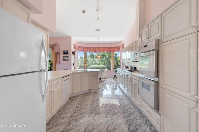 kitchen with hanging light fixtures, sink, and appliances with stainless steel finishes