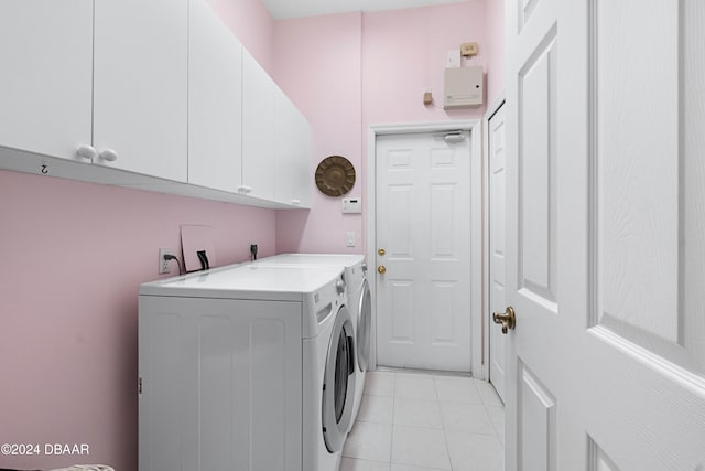 clothes washing area featuring cabinets and washing machine and clothes dryer