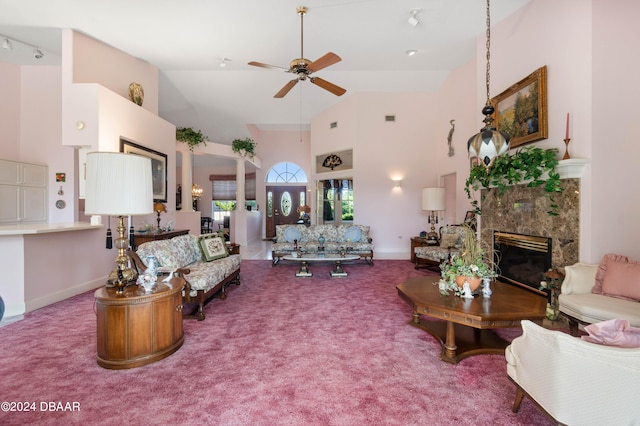 carpeted living room featuring a fireplace, ceiling fan, and high vaulted ceiling