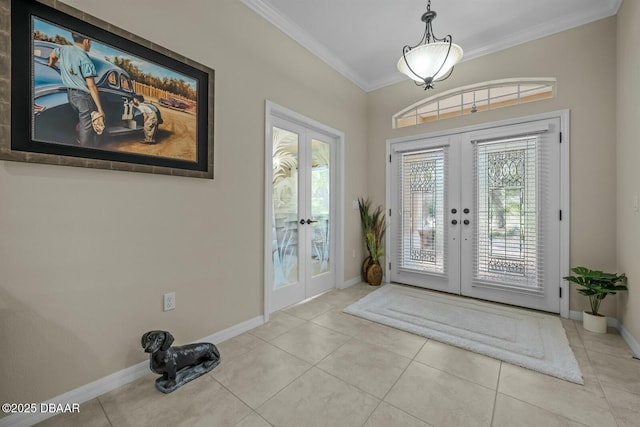 tiled entrance foyer featuring baseboards, ornamental molding, and french doors