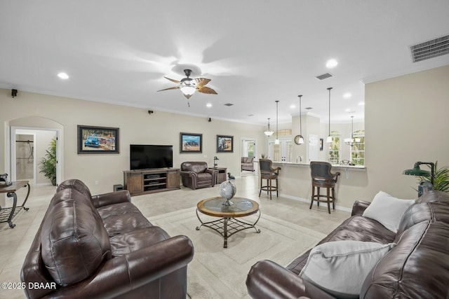 living area with light tile patterned floors, ornamental molding, visible vents, and recessed lighting