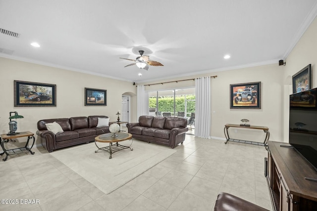 living room with arched walkways, visible vents, ornamental molding, ceiling fan, and baseboards