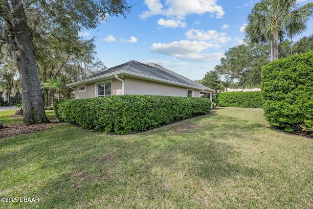 view of property exterior featuring a lawn and stucco siding