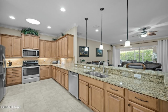 kitchen with stainless steel appliances, ornamental molding, and a sink